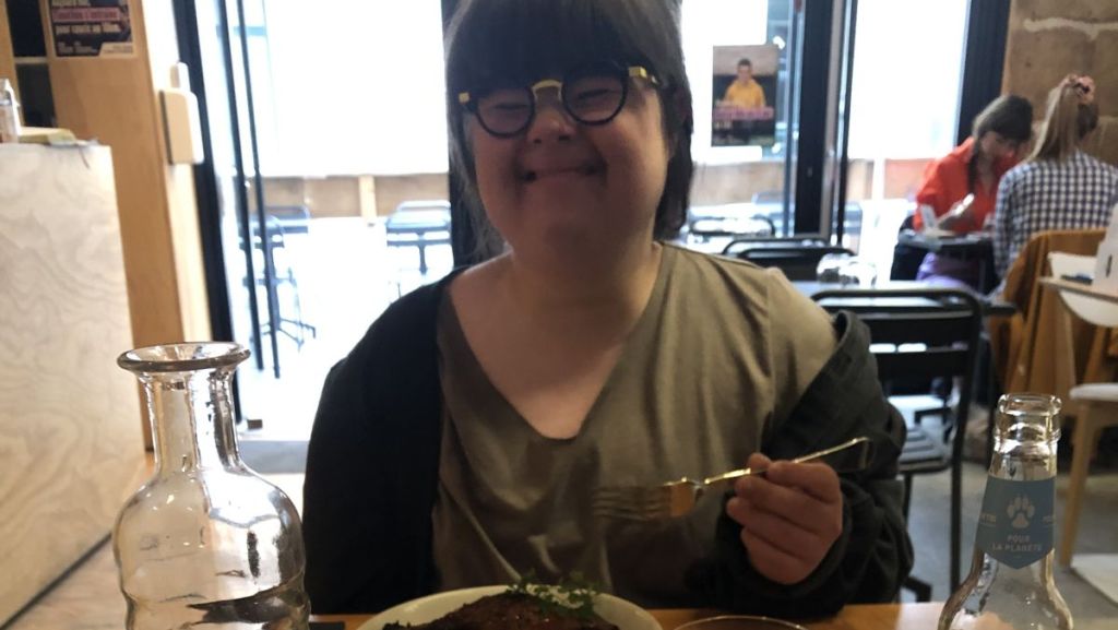 Jeanne au Reflet, souriante devant son plat