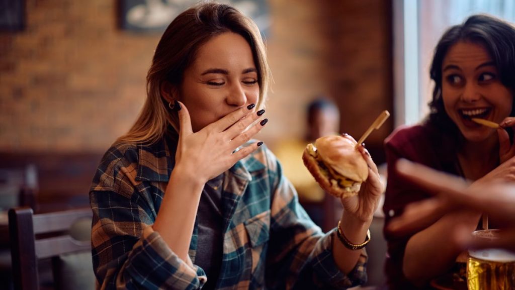 Une femme qui mange un fast food !