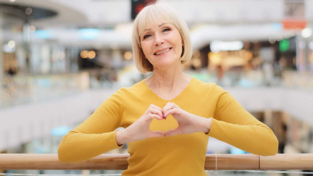 Femme de 60 ans qui fait un coeur avec les mains