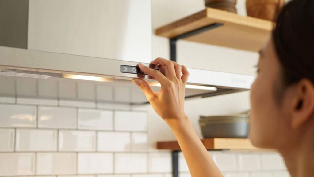 Femme devant une hotte aspirante