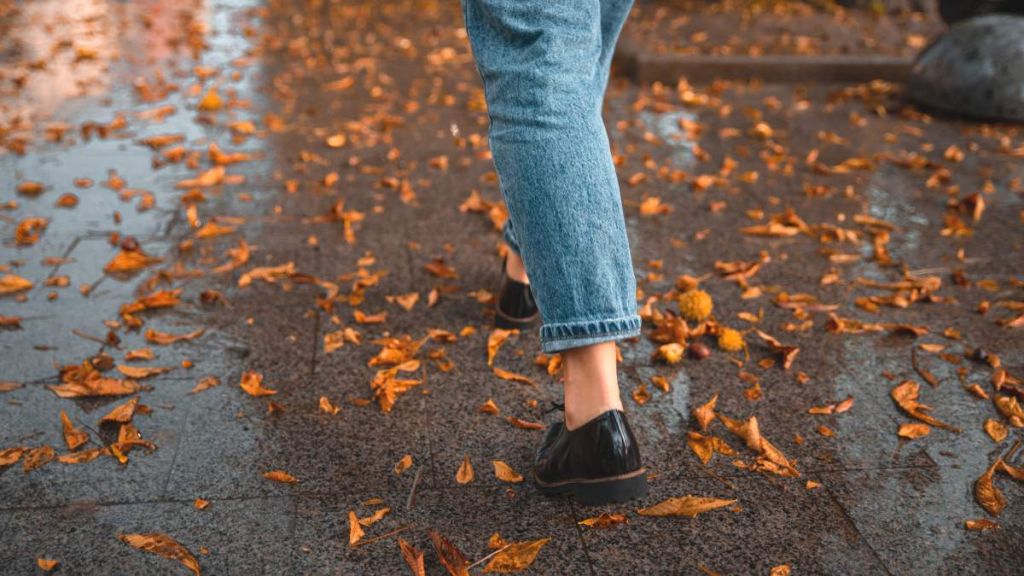 Femme qui marche dans les feuilles d'automne