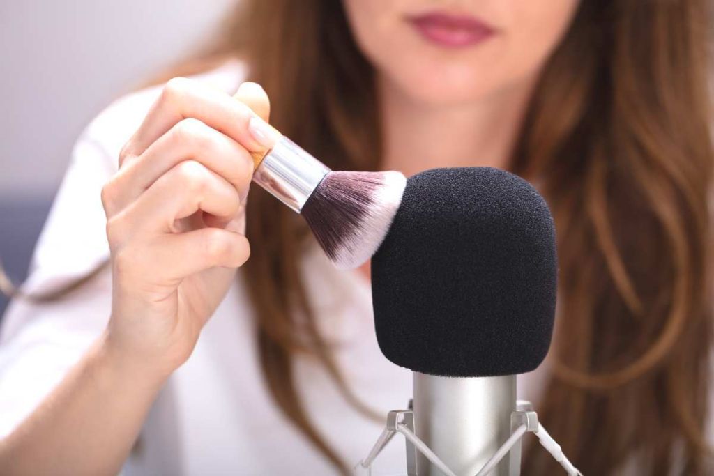 Femme qui fait du bruit en passane un pinceau sur un micro
