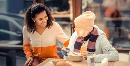 Une femme qui accompagne une sans abri au restaurant