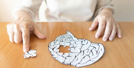 Mains qui retirent un morceau d'un cerveau dessiné, façon puzzle