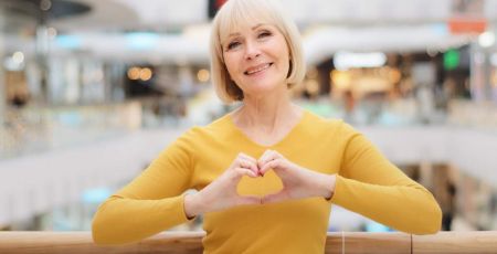 Femme de 60 ans qui fait un coeur avec les mains
