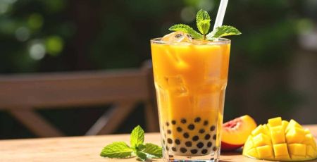 Grande verre de bubble tea orange avec des perles au fond et une paille