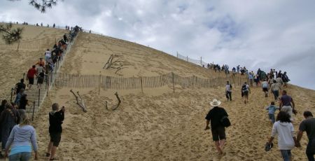 Des touristes gravissent la Dune du Pilat, en Gironde.