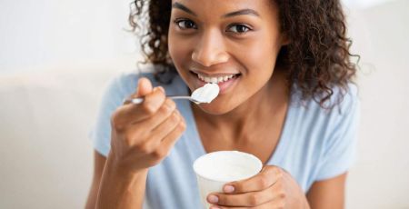Jeune femme qui mange un yaourt