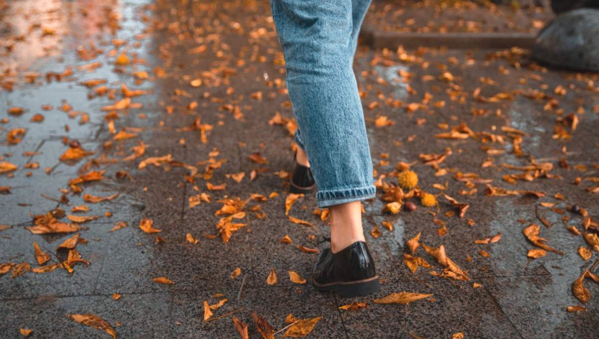 Femme qui marche dans les feuilles d'automne