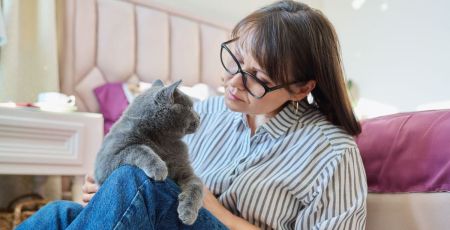 Une femme regarde tendrement son chat gris