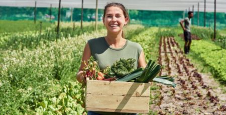 Une femme qui vient de récolter des légumes.