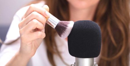 Femme qui fait du bruit en passane un pinceau sur un micro