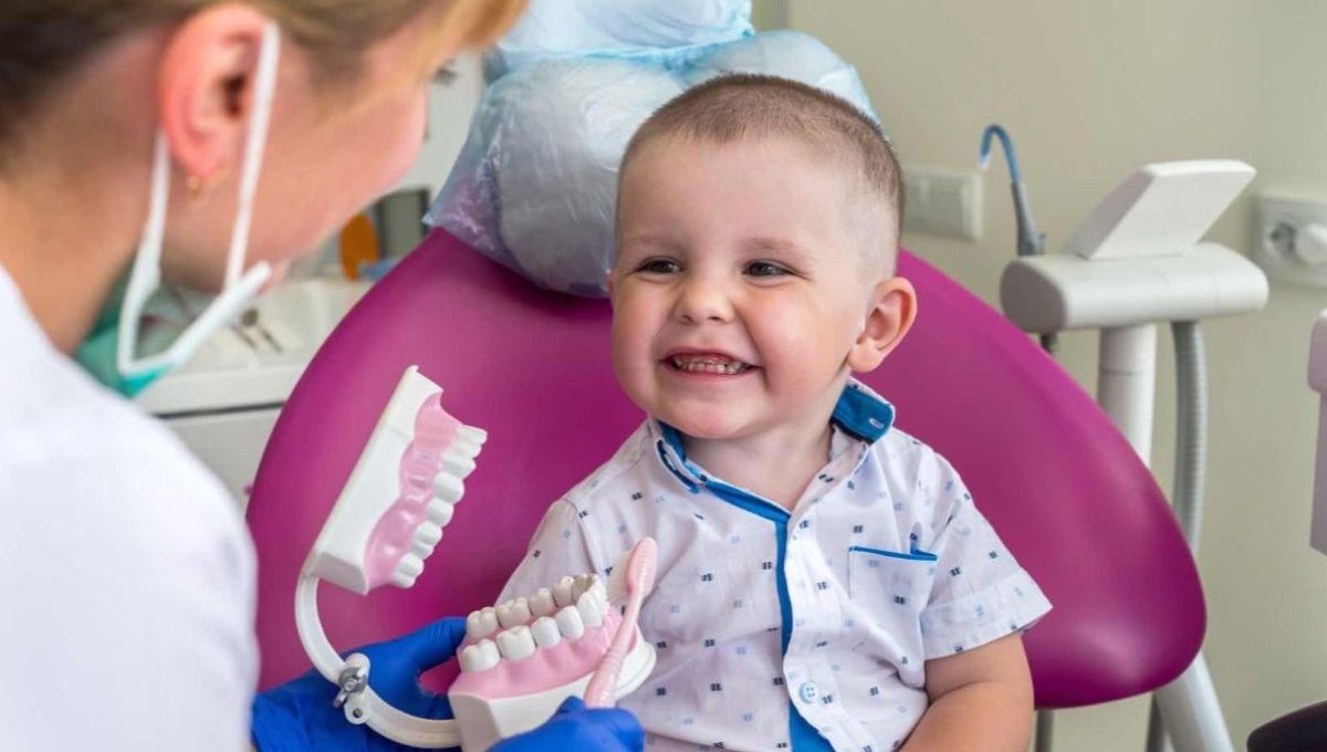Un petit garçon sourit de toutes ses dents chez le dentiste.